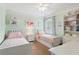 Bright bedroom featuring two twin beds, shelves, and mint green walls at 4018 Rhyne Se Cir, Smyrna, GA 30082