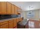 The kitchen has light wood cabinets, hardwood floors, and black countertops at 954 Josie Ct, Lawrenceville, GA 30045