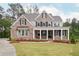 Charming two-story brick home with a welcoming front porch and meticulously manicured lawn at 1073 Sweet Mia Ln, Powder Springs, GA 30127