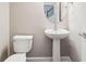 Elegant powder room with a pedestal sink, toilet, and decorative mirror at 2252 Limehurst Ne Dr, Atlanta, GA 30319