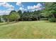 Lush backyard with mature trees, offering a serene and private outdoor space for relaxation and entertaining at 3120 Caney Creek Ln, Cumming, GA 30041