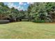 Expansive backyard featuring a well-maintained lawn and mature trees providing shade and privacy at 3120 Caney Creek Ln, Cumming, GA 30041