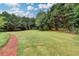 Well-manicured backyard featuring a spacious lawn and mature trees, creating a peaceful outdoor environment at 3120 Caney Creek Ln, Cumming, GA 30041