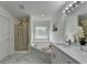 Primary bath boasts large soaking tub, custom window and double vanity with marble countertops at 3120 Caney Creek Ln, Cumming, GA 30041