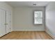 Bright bedroom with wood floors, ceiling fan, and natural light from the window at 3120 Caney Creek Ln, Cumming, GA 30041