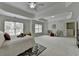 Bright primary bedroom featuring a ceiling fan, tray ceilings, sitting area, and large windows at 3120 Caney Creek Ln, Cumming, GA 30041