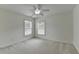 This bedroom features a ceiling fan, two windows, and light colored walls at 3120 Caney Creek Ln, Cumming, GA 30041