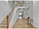 Open foyer with hardwood floors, wainscoting detail, staircase and views of the kitchen at 3120 Caney Creek Ln, Cumming, GA 30041