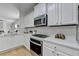 Modern kitchen featuring white cabinets, quartz countertops, and stainless steel appliances at 3120 Caney Creek Ln, Cumming, GA 30041