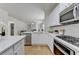 Bright, open kitchen with white cabinetry, stainless steel appliances, and views to the living area at 3120 Caney Creek Ln, Cumming, GA 30041