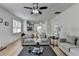 Open-concept living room with wood floors, ceiling fan, and bright natural light at 3120 Caney Creek Ln, Cumming, GA 30041