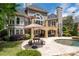 A luxurious backyard featuring a pool, patio, outdoor kitchen, and spiral staircase at 5860 Stoneleigh Dr, Suwanee, GA 30024