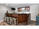 Basement wet bar featuring dark wood cabinets and countertop with seating for five at 5860 Stoneleigh Dr, Suwanee, GA 30024