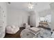 Bright bedroom featuring a ceiling fan, sitting area, hardwood floors, and lots of natural light at 5860 Stoneleigh Dr, Suwanee, GA 30024