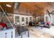 Covered patio with a wood ceiling, stone floor, cozy seating, and access to the backyard at 5860 Stoneleigh Dr, Suwanee, GA 30024