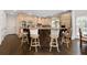 Kitchen island with custom cabinetry, granite countertops, and seating for four at 5860 Stoneleigh Dr, Suwanee, GA 30024