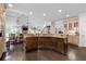 Open concept kitchen with granite counters and dark wood island, adjacent dining area at 5860 Stoneleigh Dr, Suwanee, GA 30024