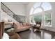 Elegant living room featuring a soaring ceiling, a large arched window, and a staircase with iron railings at 5860 Stoneleigh Dr, Suwanee, GA 30024