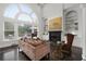 Bright and airy living room with a fireplace, built-in bookshelves, and soaring arched windows at 5860 Stoneleigh Dr, Suwanee, GA 30024