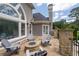 Outdoor patio showing a stone firepit and stone columns with a view of the trees in the backyard at 5860 Stoneleigh Dr, Suwanee, GA 30024