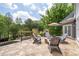 Outdoor patio is arranged with comfortable chairs around a cozy stone fire pit with natural surroundings at 5860 Stoneleigh Dr, Suwanee, GA 30024