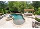 Inviting backyard features a stone pool, hot tub, pergola, and an outdoor kitchen area at 5860 Stoneleigh Dr, Suwanee, GA 30024