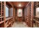 Elegant wine cellar with custom wood racking, stone tile floor, and a small window at 5860 Stoneleigh Dr, Suwanee, GA 30024