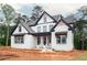 Newly constructed white brick home with black trim and covered porch on a wooded lot at 1072 Sweet Mia Ln, Powder Springs, GA 30127