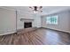 Spacious living room features a cozy fireplace, ceiling fan, and stylish wood-look flooring at 5666 Goldfield Dr, Acworth, GA 30102