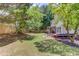 Spacious backyard featuring a wooden fence, mature trees, patio set, and outdoor seating at 1370 Stoney Field Place, Lawrenceville, GA 30043