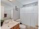 Well-lit bathroom with a single sink, vanity, toilet, and shower with curtain at 1370 Stoney Field Place, Lawrenceville, GA 30043