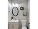 Elegant half bathroom featuring modern fixtures, decorative mirror, and neutral color scheme at 1370 Stoney Field Place, Lawrenceville, GA 30043