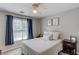 Cozy bedroom featuring a large window, curtains, and bedside table at 1370 Stoney Field Place, Lawrenceville, GA 30043