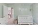 Light green Bedroom features a crib and a view into a hall way at 1370 Stoney Field Place, Lawrenceville, GA 30043