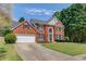 Traditional-style home boasting a lush green lawn, classic brick facade, and a two-car garage at 1370 Stoney Field Place, Lawrenceville, GA 30043
