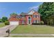 Charming brick home featuring a well-manicured lawn, two-car garage, and beautiful landscaping at 1370 Stoney Field Place, Lawrenceville, GA 30043