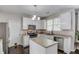Well-lit kitchen with white cabinets, stainless steel appliances, dark hardwood flooring, and a central island at 1370 Stoney Field Place, Lawrenceville, GA 30043
