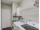 Functional laundry room with modern washer and dryer, storage shelf, and white door at 1370 Stoney Field Place, Lawrenceville, GA 30043