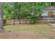 Lush backyard with a tall fence and mature trees at 1667 Sylvan Sw Rd, Atlanta, GA 30310