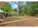 Large, grassy backyard with mature trees and partial fencing offers privacy and space at 1667 Sylvan Sw Rd, Atlanta, GA 30310
