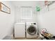 Convenient laundry room features a modern washer and dryer, plus shelving and natural light at 1667 Sylvan Sw Rd, Atlanta, GA 30310