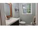 Neutral half bathroom featuring vanity with modern faucet, toilet, mirror, and window at 2859 Wood Park Nw Trce, Kennesaw, GA 30152