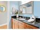 Bathroom features wood vanity with granite countertop, stylish mirror, lighting, and light blue walls at 325 E Paces Ferry Rd # 2003, Atlanta, GA 30305