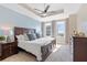 Spacious bedroom with a tray ceiling, ceiling fan, two windows, and dark wood furnishings at 325 E Paces Ferry Rd # 2003, Atlanta, GA 30305