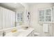 Bright bathroom with white vanity, gold fixtures, framed mirror, and shuttered window at 5270 Forest Brook Pkwy, Marietta, GA 30068