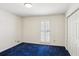 This bedroom features white walls, blue carpet, and natural light from a window with white shutters at 5270 Forest Brook Pkwy, Marietta, GA 30068