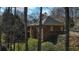 Back of brick home with many windows and surrounding foliage viewed through trees at 5270 Forest Brook Pkwy, Marietta, GA 30068