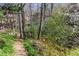Lush greenery and trees surround a path and slope leading down to the property at 5270 Forest Brook Pkwy, Marietta, GA 30068