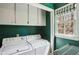 Laundry room features a washer, dryer, storage cabinets, and a window for natural light at 5270 Forest Brook Pkwy, Marietta, GA 30068