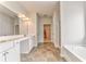 Bright bathroom with double vanity, tub, tiled floor, and walk-in closet access at 101 Wins Walk, Cartersville, GA 30121
